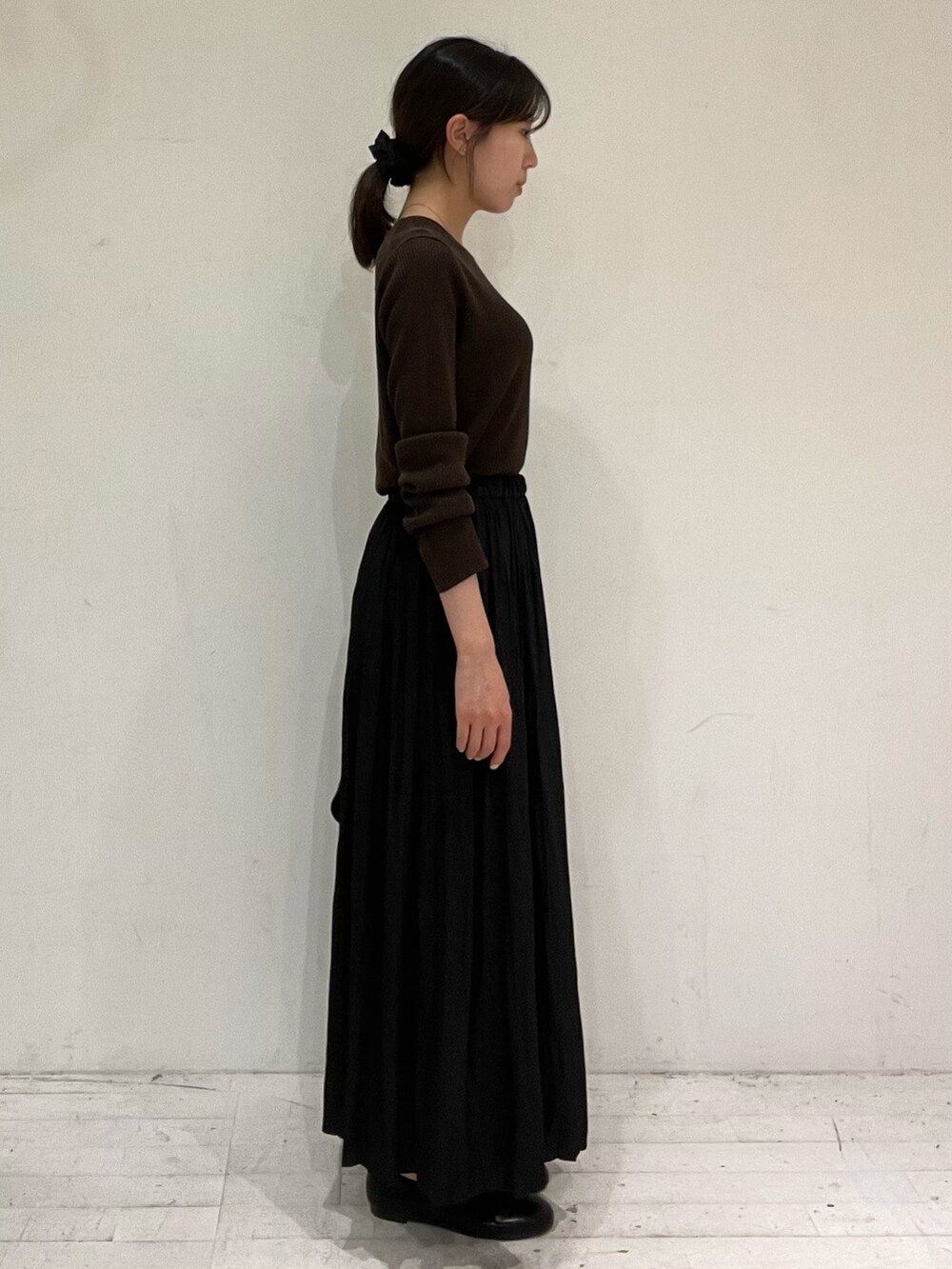 ブラウン系のニット/セーター、ブラック系のショルダーバッグ、ブラック系のバレエシューズを着用したレディースの秋コーディネートの3枚目の写真