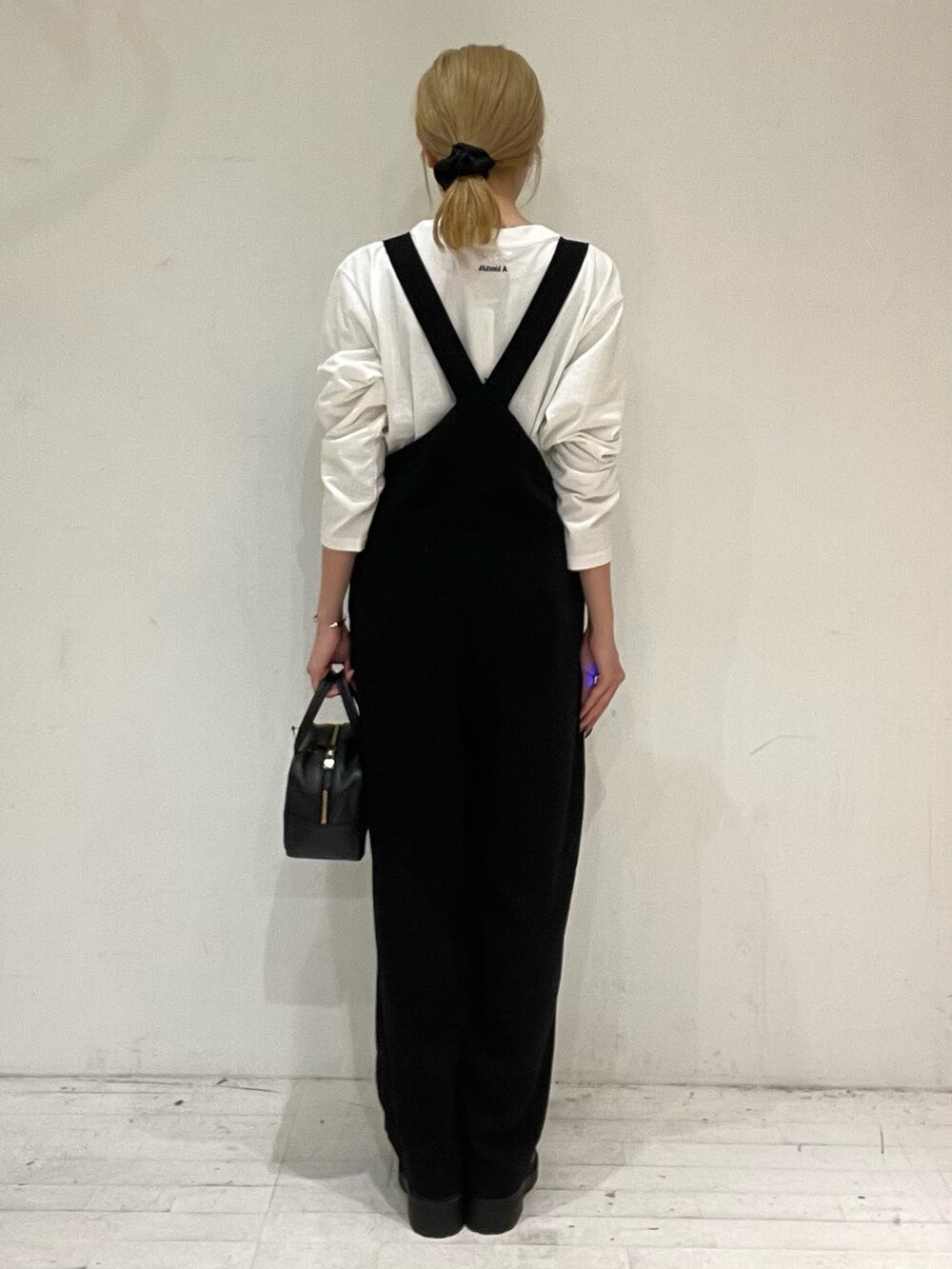 ブルー系のTシャツ/カットソー、ブラック系のボストンバッグ、ブラック系のブーツを着用したレディースの秋コーディネートの4枚目の写真