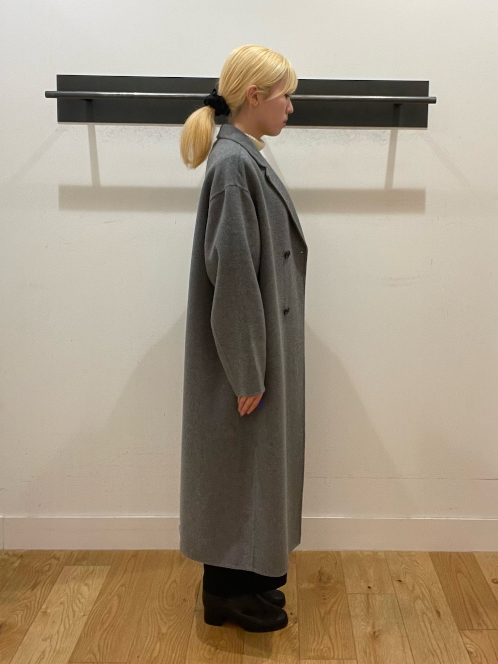 ブラック系のハンドバッグ、ブラック系のブーツ、ホワイト系のニット/セーターを着用したレディースの冬コーディネートの3枚目の写真