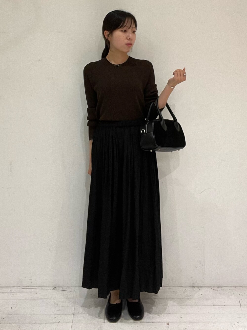 ブラウン系のニット/セーター、ブラック系のショルダーバッグ、ブラック系のバレエシューズを着用したレディースの秋コーディネートの2枚目の写真