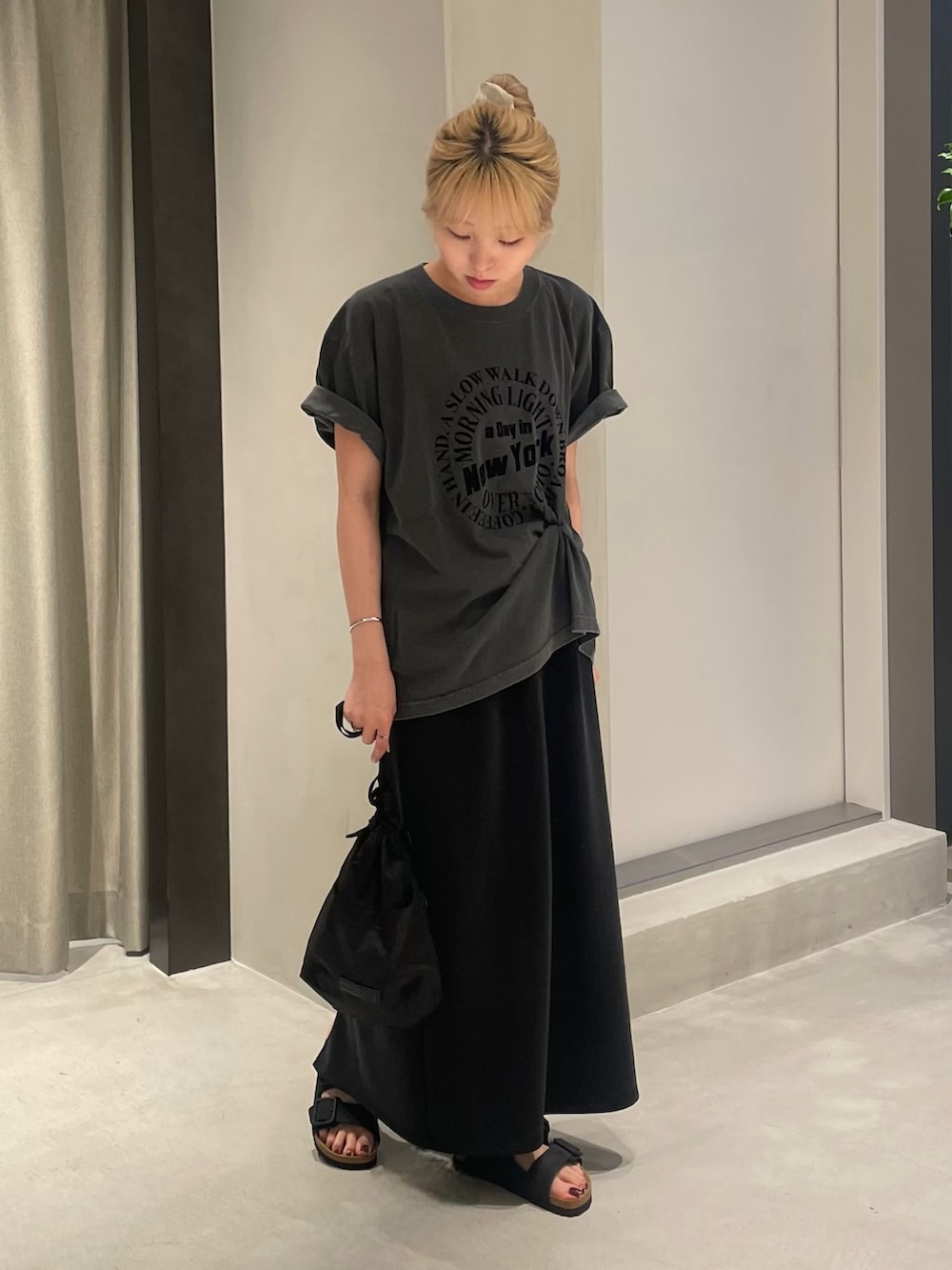 ブラック系のTシャツ/カットソー、ブラック系のスカート、ブラック系のショルダーバッグを着用したレディースの夏コーディネートの3枚目の写真