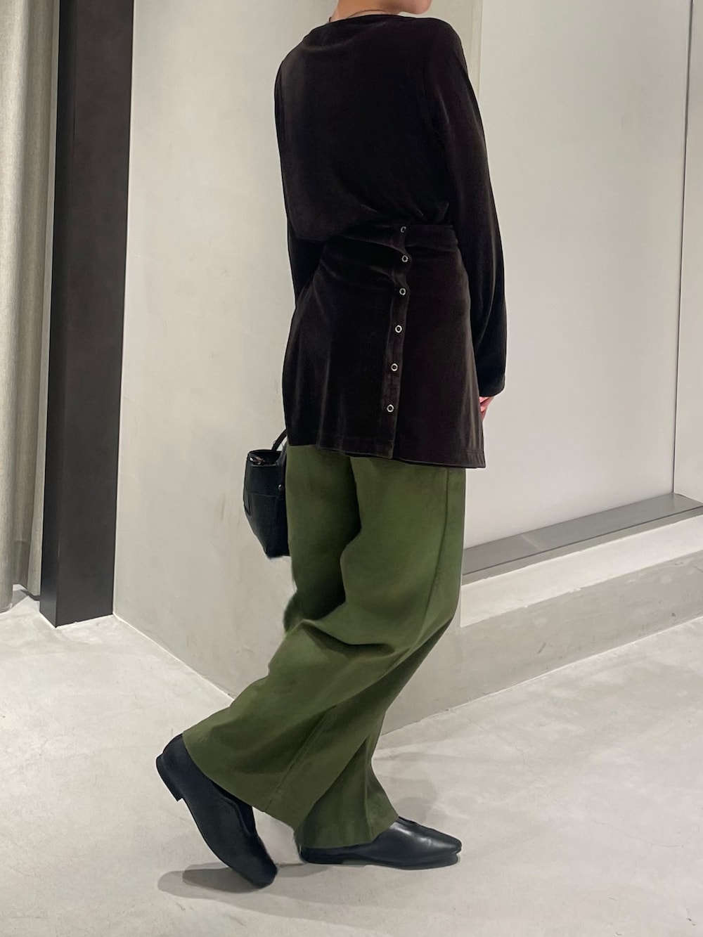 ブラック系のスリッポン、グリーン系のその他パンツ、ブラック系のハンドバッグを着用したレディースの秋コーディネートの3枚目の写真