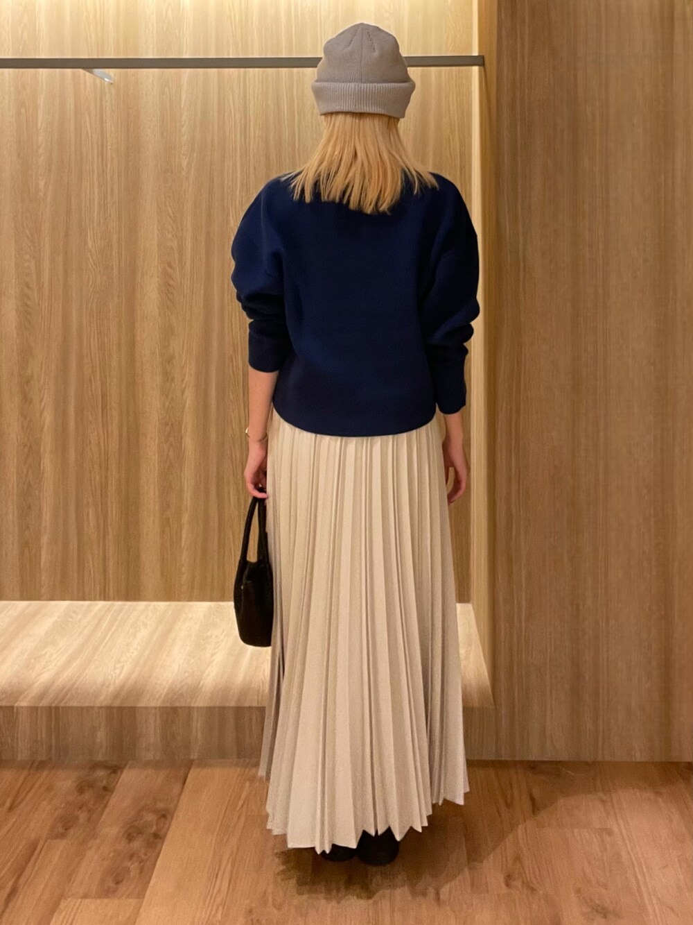 ブラック系のハンドバッグ、ブラック系のブーツ、ブルー系のその他アウターを着用したレディースの冬コーディネートの6枚目の写真