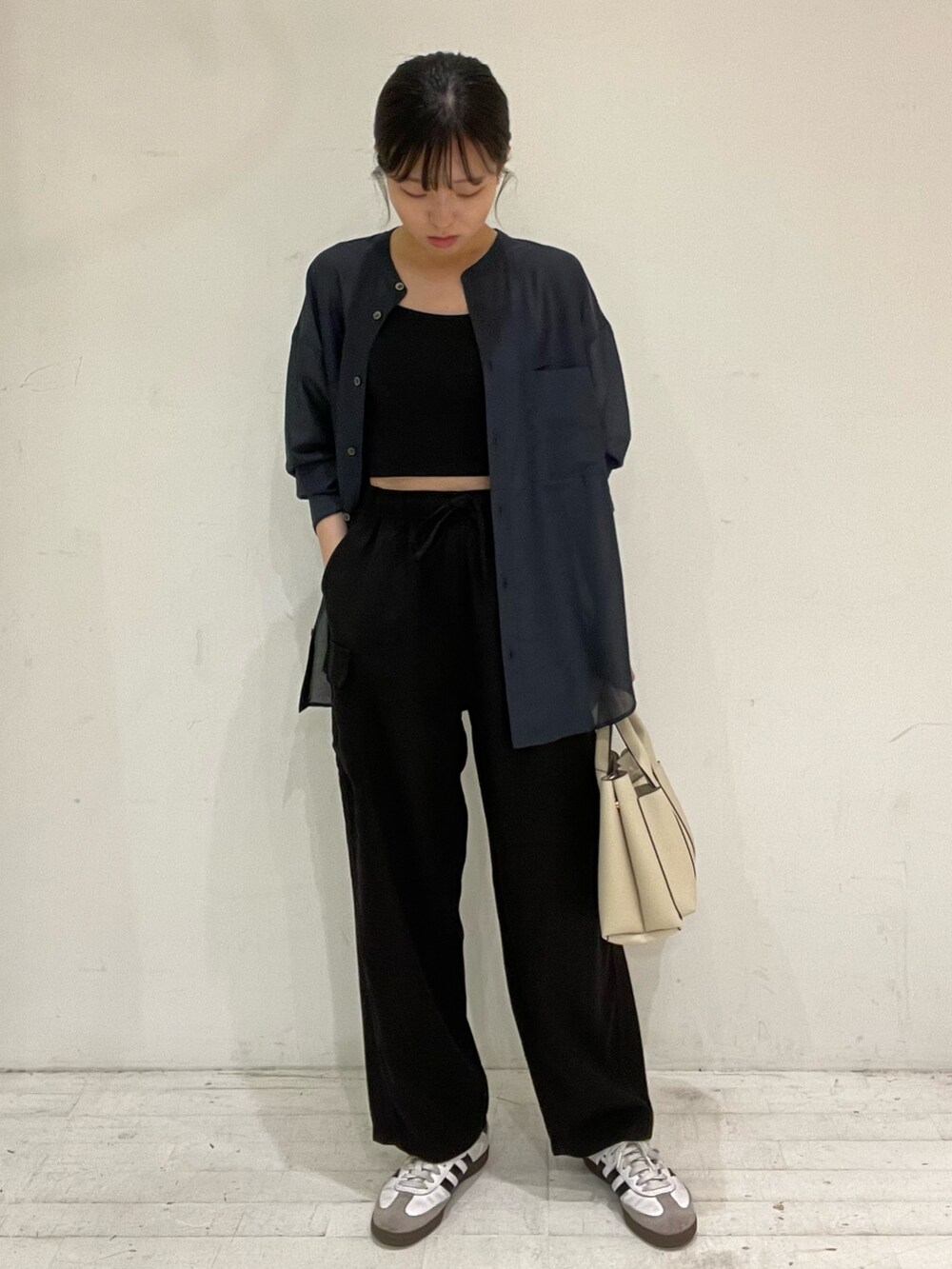 ブルー系のシャツ/ブラウス、ホワイト系のスニーカー、ブラック系のその他パンツを着用したレディースの秋コーディネートの2枚目の写真