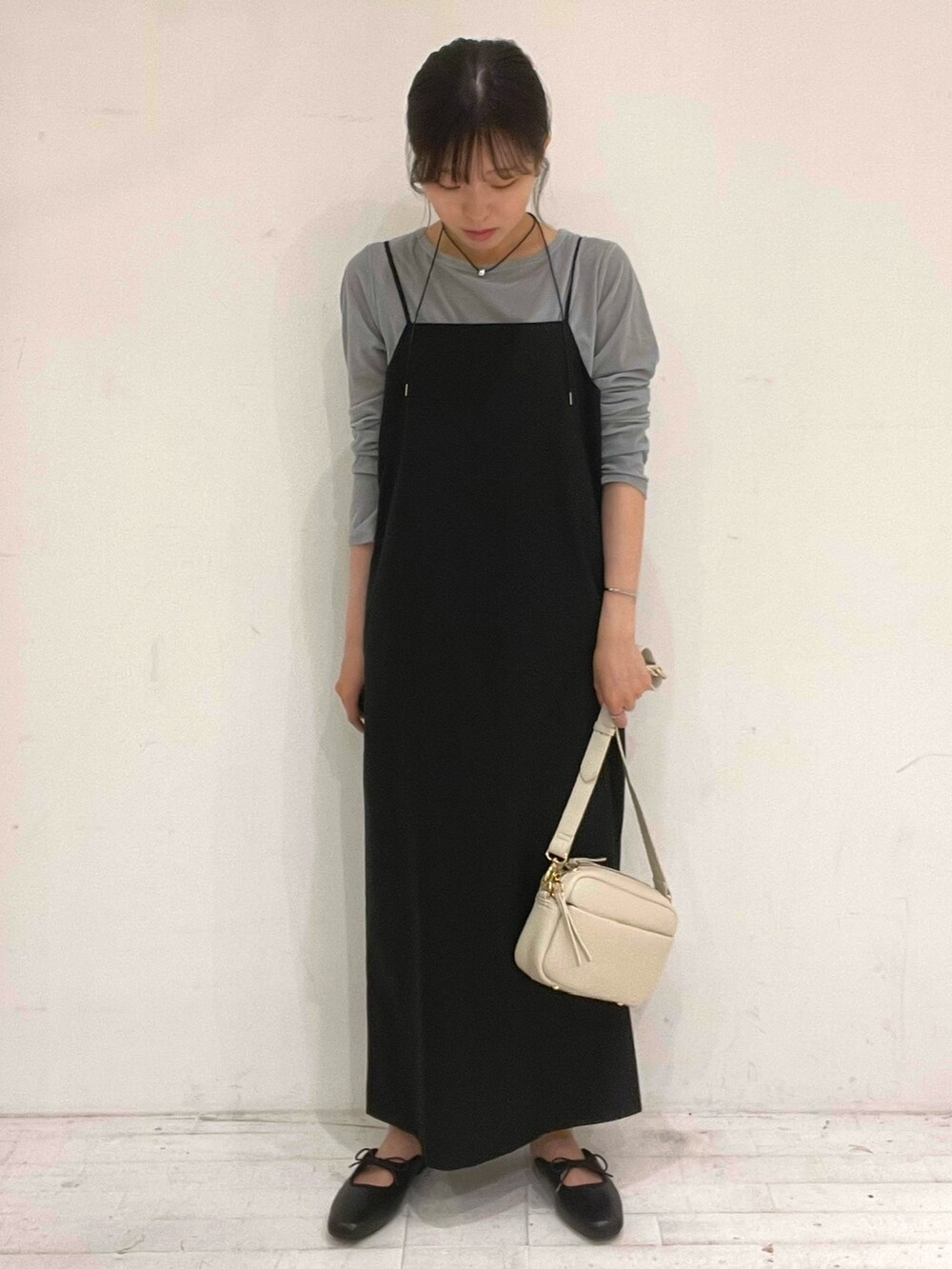 ブラック系のワンピース、ブラック系のサンダル、ホワイト系のショルダーバッグを着用したレディースの秋コーディネートの2枚目の写真