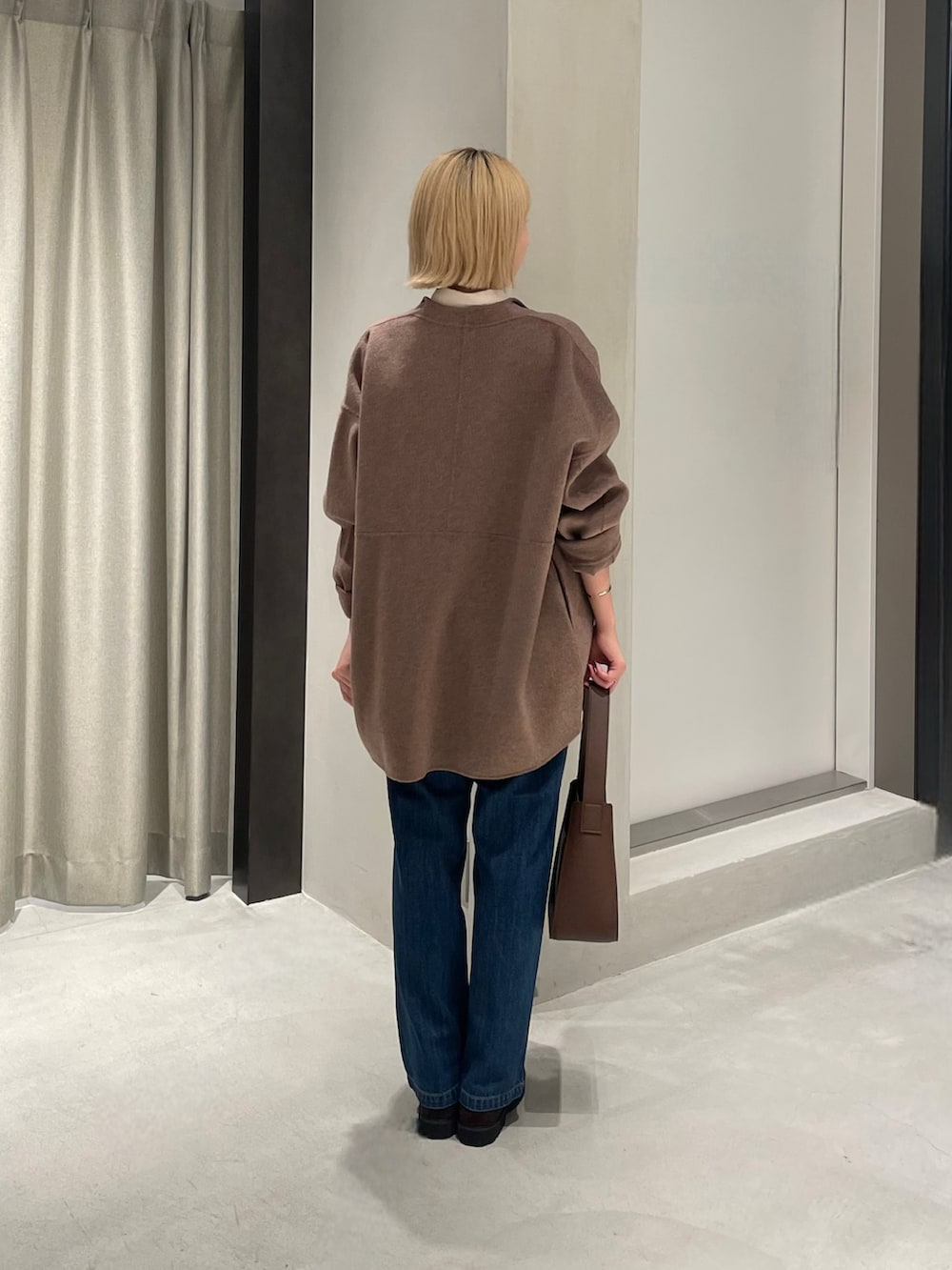 ブラウン系のその他アウター、ベージュ系のシャツ/ブラウス、ブルー系のデニムパンツを着用したレディースの秋コーディネートの4枚目の写真