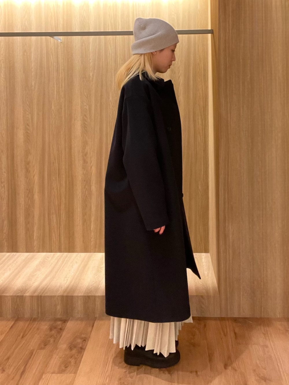 ブラック系のハンドバッグ、ブラック系のブーツ、ブルー系のその他アウターを着用したレディースの冬コーディネートの3枚目の写真