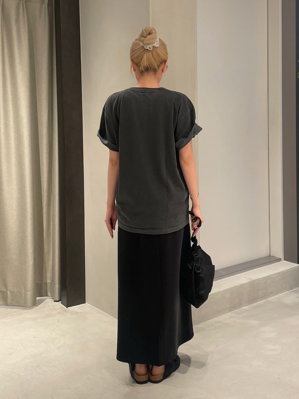 ブラック系のTシャツ/カットソー、ブラック系のスカート、ブラック系のショルダーバッグを着用したレディースの夏コーディネートの5枚目の写真