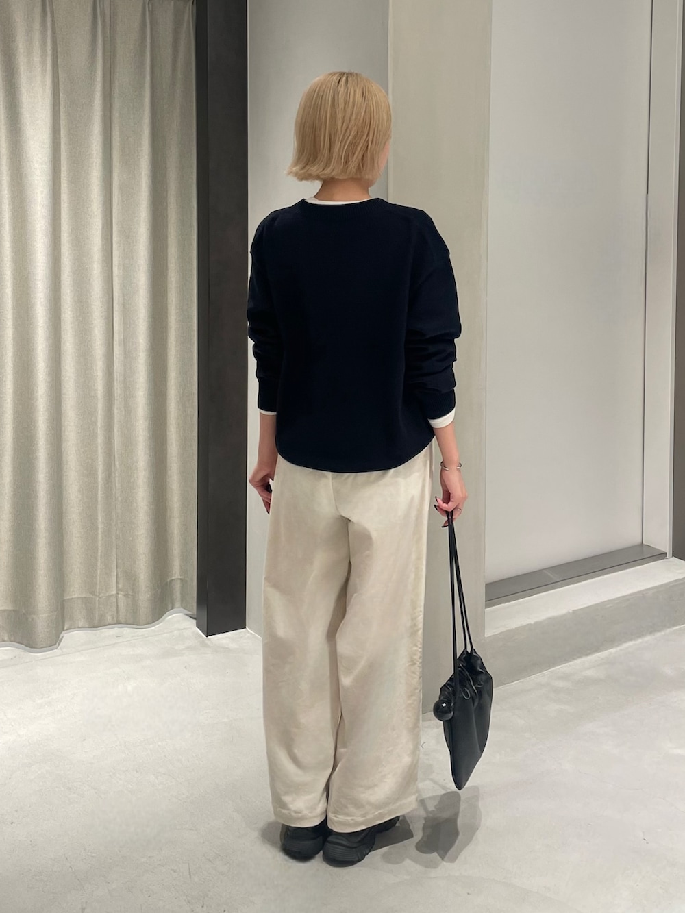 ブラック系のスニーカー、ブルー系のニット/セーター、ホワイト系のTシャツ/カットソーを着用したレディースの秋コーディネートの5枚目の写真