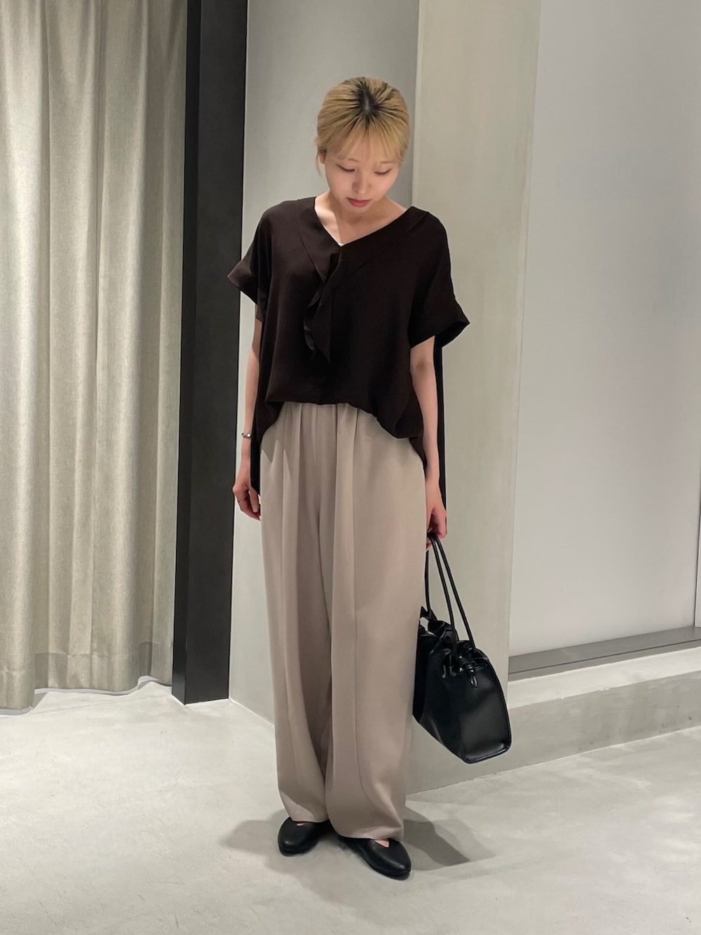 ブラック系のトートバッグ、ブラック系のパンプス、ベージュ系のその他パンツを着用したレディースの夏コーディネートの2枚目の写真