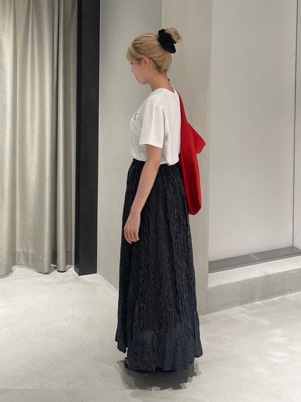 レッド系のショルダーバッグ、ブラック系のサンダル、ホワイト系のTシャツ/カットソーを着用したレディースの夏コーディネートの4枚目の写真