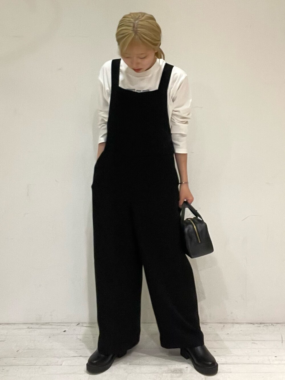 ブルー系のTシャツ/カットソー、ブラック系のボストンバッグ、ブラック系のブーツを着用したレディースの秋コーディネートの2枚目の写真