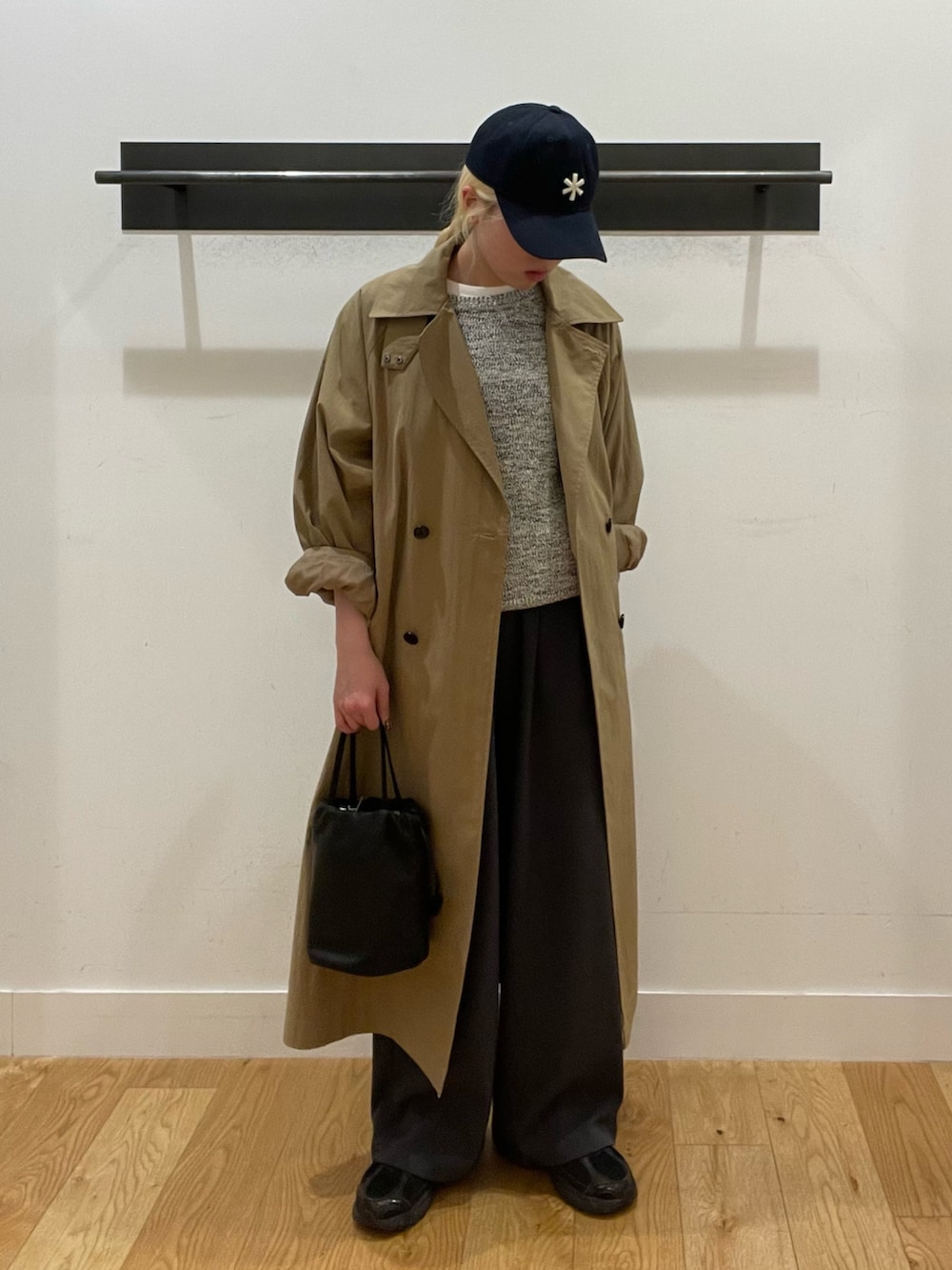 ベージュ系のトレンチコート、グレー系のその他パンツ、ブラック系のスニーカーを着用したレディースの春コーディネートの2枚目の写真