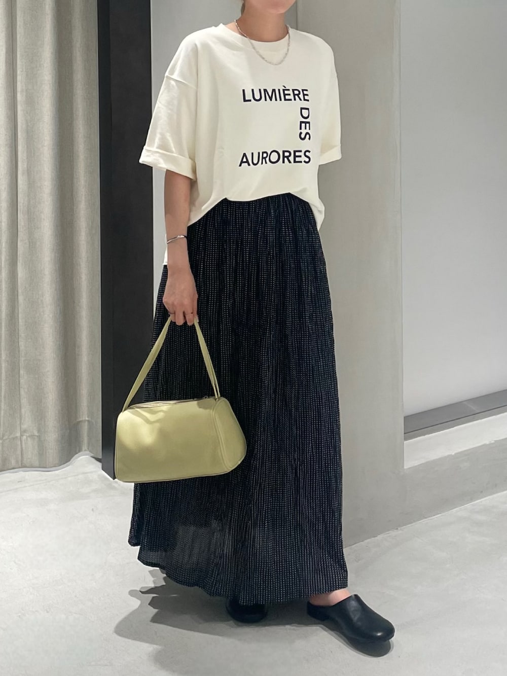ブラック系のその他シューズ、ブラック系のスカート、ベージュ系のTシャツ/カットソーを着用したレディースの夏コーディネートの3枚目の写真