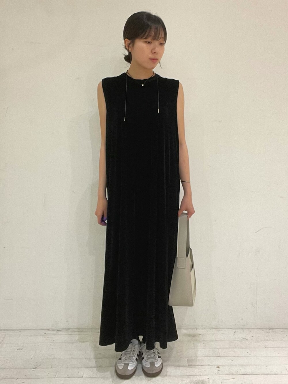 ブラック系のワンピース、ホワイト系のスニーカー、グレー系のハンドバッグを着用したレディースの秋コーディネートの2枚目の写真