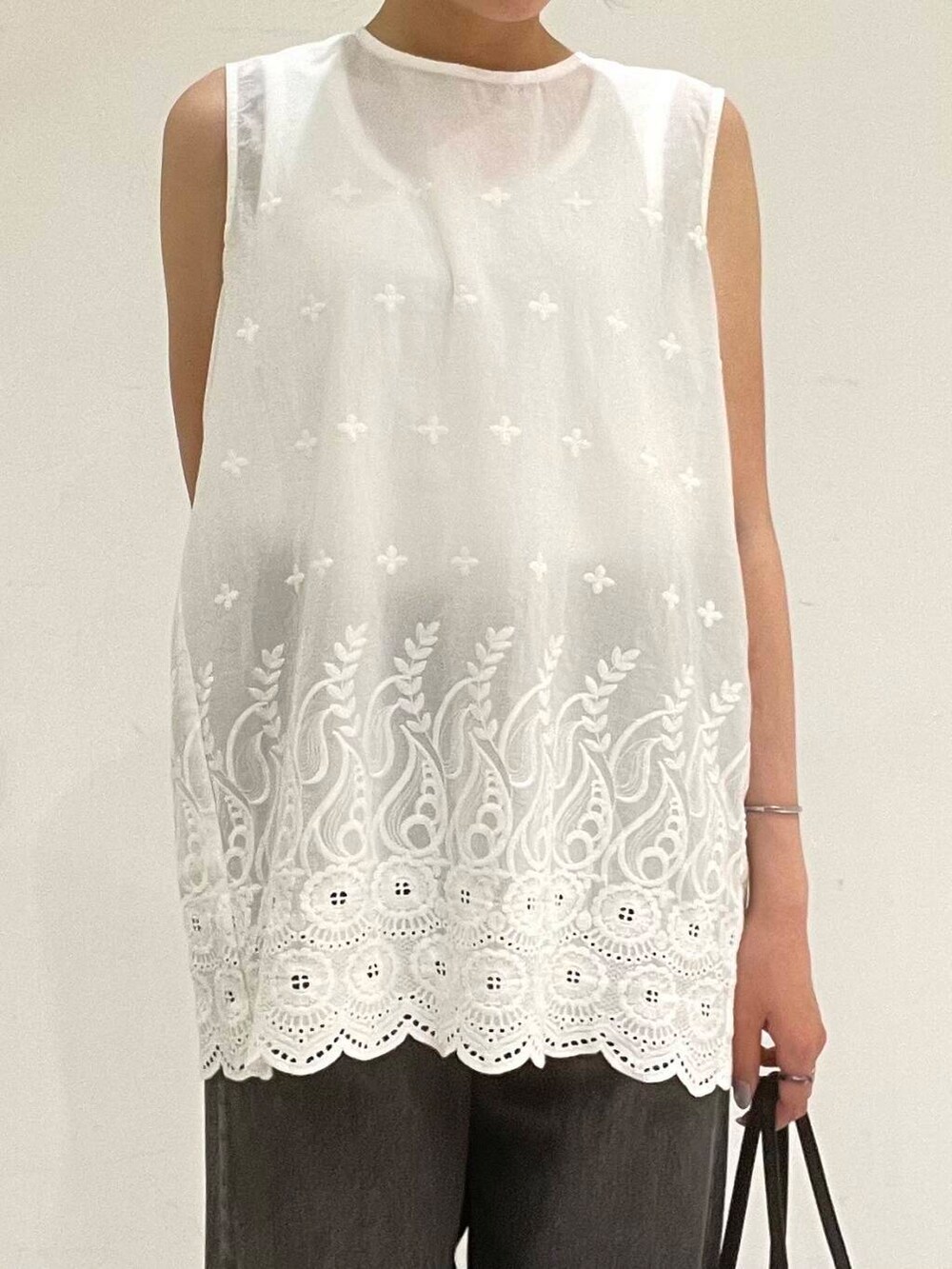 ブラック系のサンダル、ブラック系のボストンバッグ、ホワイト系のシャツ/ブラウスを着用したレディースの夏コーディネートの4枚目の写真