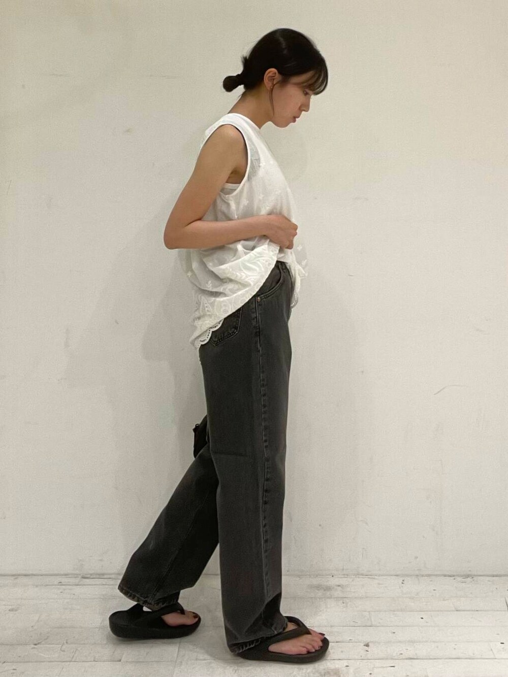 ブラック系のサンダル、ブラック系のボストンバッグ、ホワイト系のシャツ/ブラウスを着用したレディースの夏コーディネートの2枚目の写真