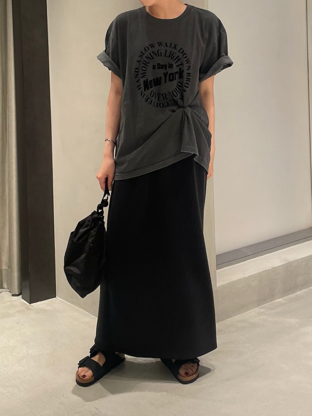 ブラック系のTシャツ/カットソー、ブラック系のスカート、ブラック系のショルダーバッグを着用したレディースの夏コーディネートの2枚目の写真
