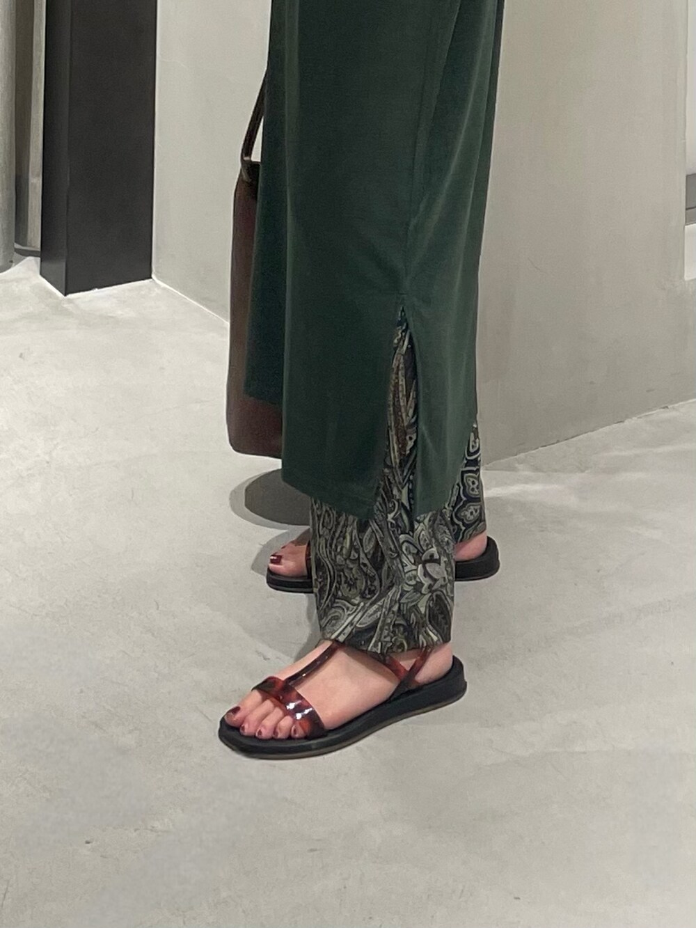 グリーン系のワンピース、ブラウン系のその他パンツ、ブラック系のサンダルを着用したレディースの夏コーディネートの4枚目の写真