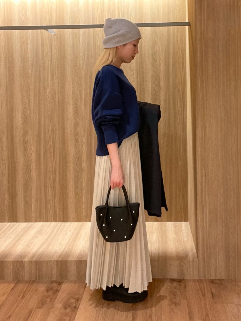 ブラック系のハンドバッグ、ブラック系のブーツ、ブルー系のその他アウターを着用したレディースの冬コーディネートの5枚目の写真