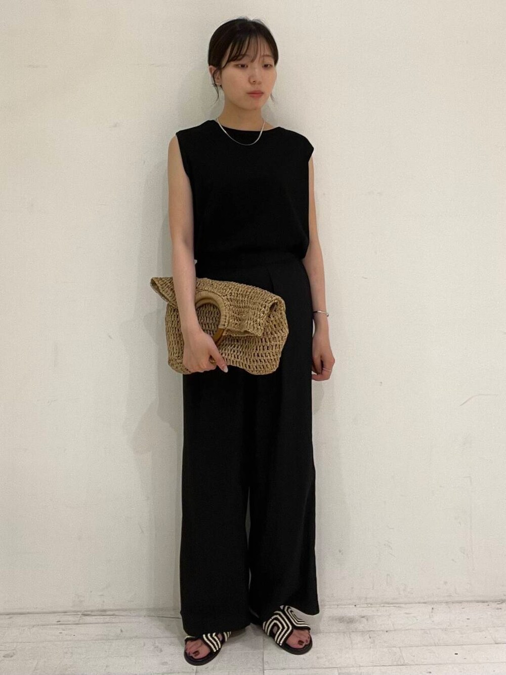 ベージュ系のトートバッグ、ブラック系のサンダル、ブラック系のその他パンツを着用したレディースの夏コーディネートの3枚目の写真