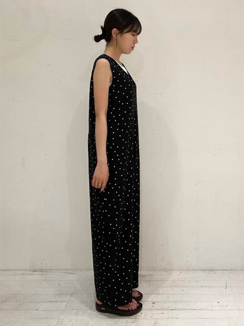 ホワイト系のタンクトップ、ブラック系のサンダル、ブラック系のサロペット/オーバーオールを着用したレディースの夏コーディネートの3枚目の写真