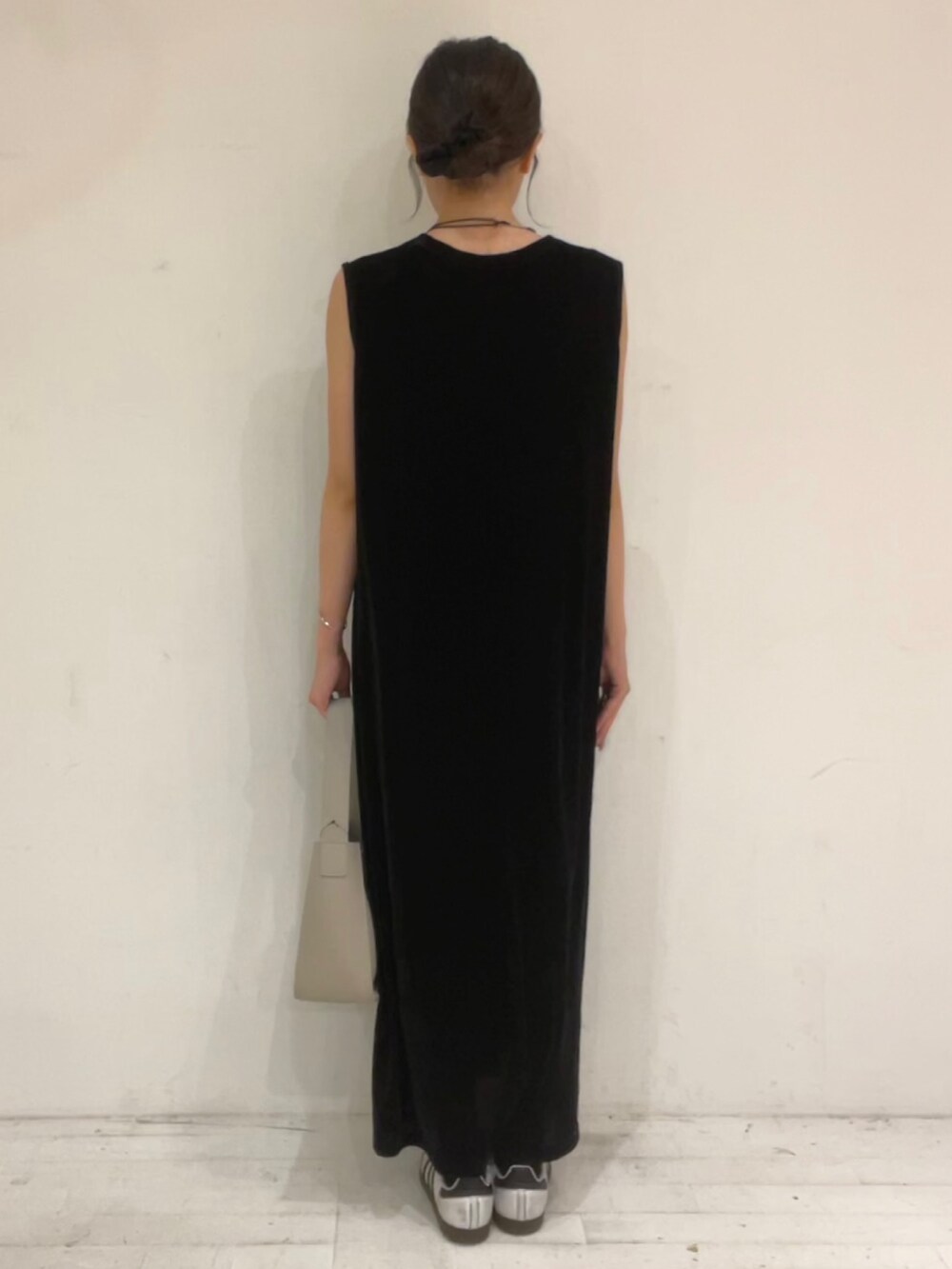 ブラック系のワンピース、ホワイト系のスニーカー、グレー系のハンドバッグを着用したレディースの秋コーディネートの4枚目の写真