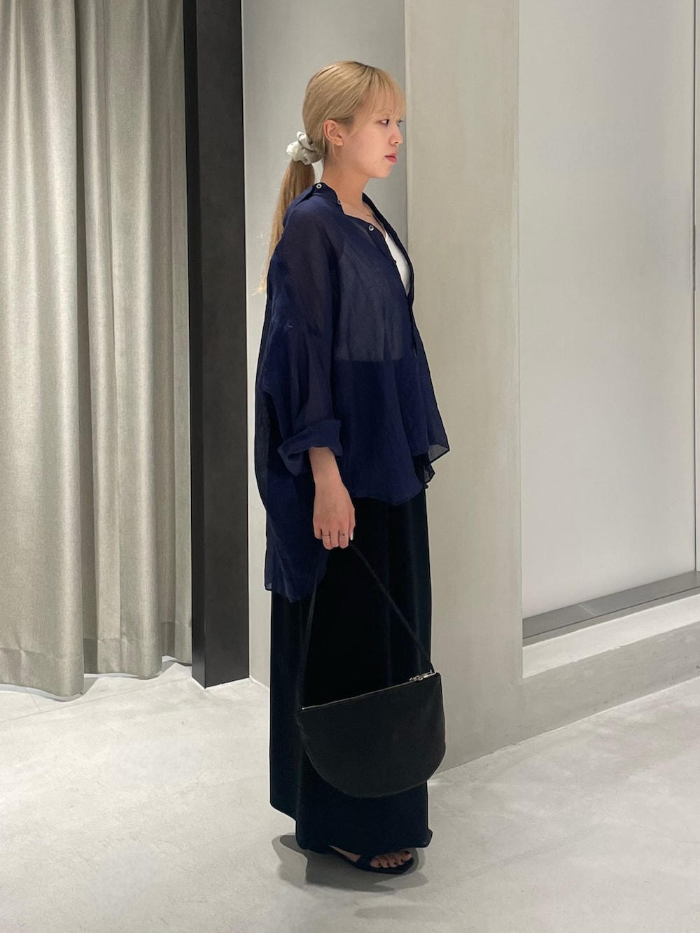 ブラック系のハンドバッグ、ブラック系のサンダル、ホワイト系のタンクトップを着用したレディースの夏コーディネートの3枚目の写真