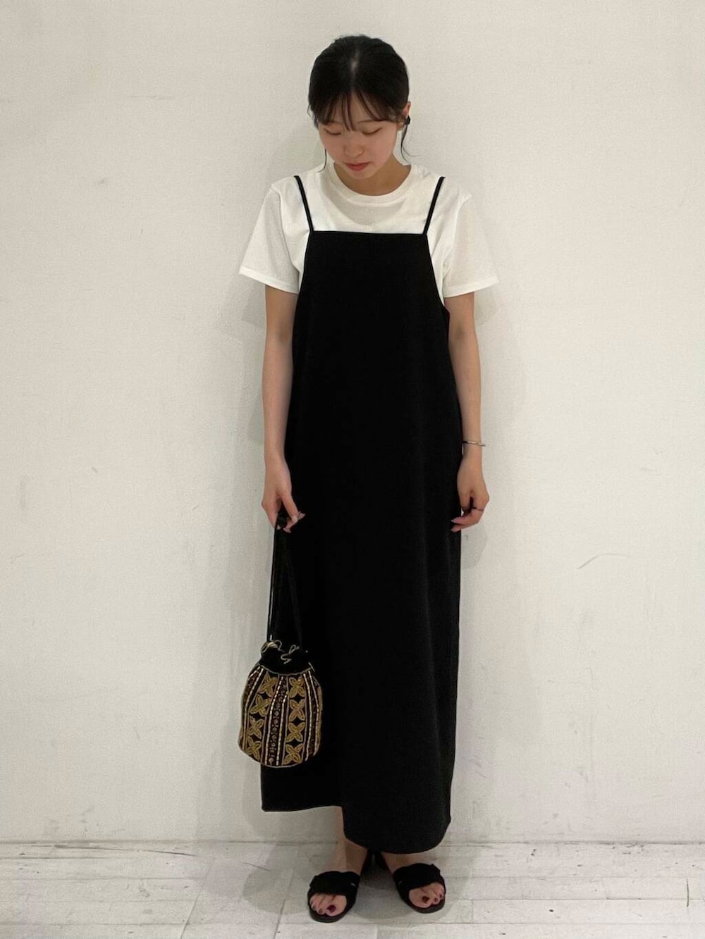 ブラック系のサンダル、ホワイト系のTシャツ/カットソー、ブラック系のショルダーバッグを着用したレディースの夏コーディネートの2枚目の写真