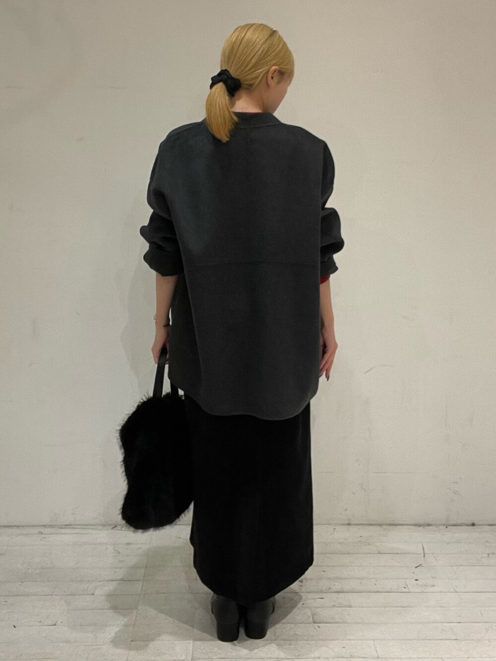 レッド系のニット/セーター、グレー系のその他アウター、ブラック系のスカートを着用したレディースの秋コーディネートの4枚目の写真