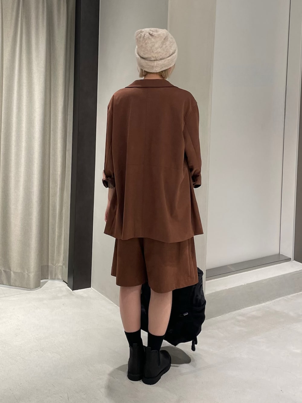 ブラック系のレインシューズ、ブラウン系のその他パンツ、ブラウン系のテーラードジャケットを着用したレディースの秋コーディネートの5枚目の写真