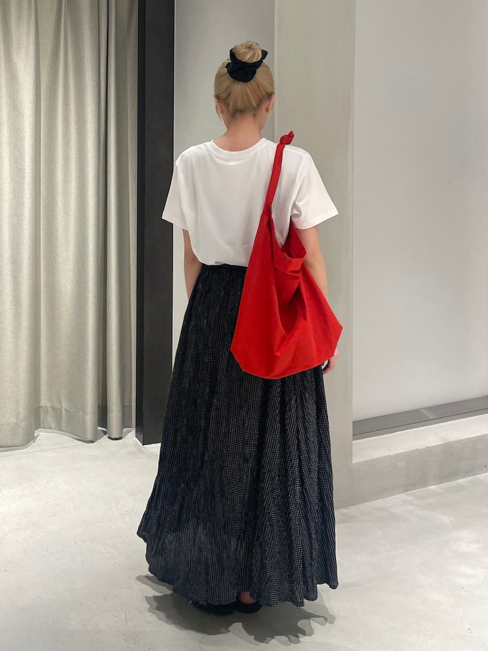 レッド系のショルダーバッグ、ブラック系のサンダル、ホワイト系のTシャツ/カットソーを着用したレディースの夏コーディネートの5枚目の写真