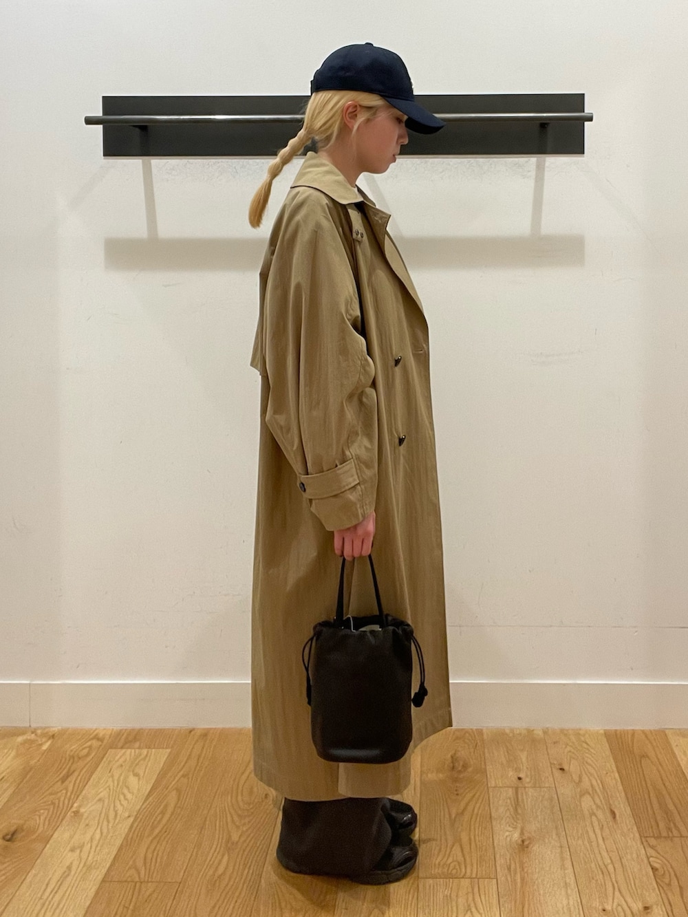 ベージュ系のトレンチコート、グレー系のその他パンツ、ブラック系のスニーカーを着用したレディースの春コーディネートの3枚目の写真