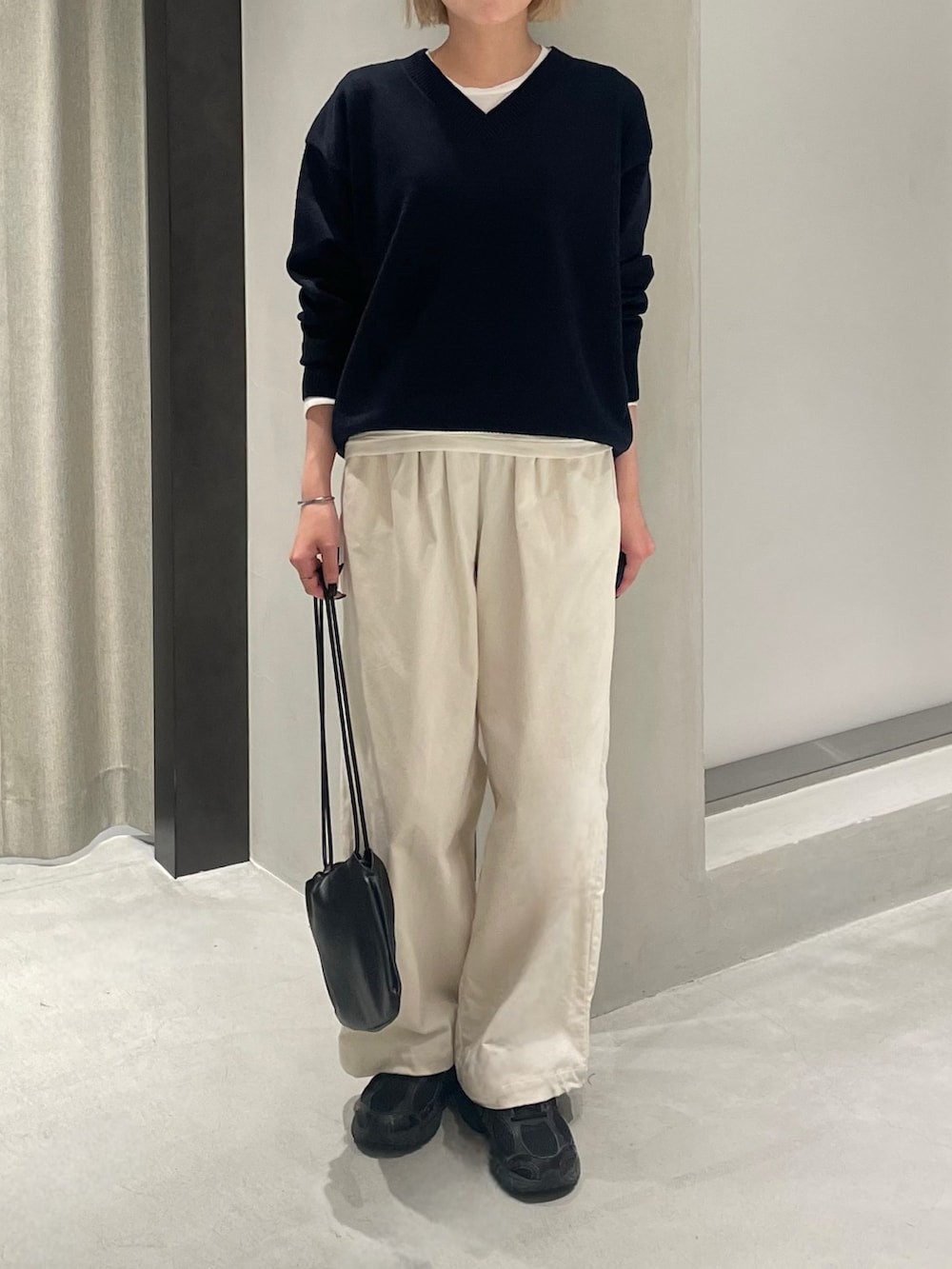 ブラック系のスニーカー、ブルー系のニット/セーター、ホワイト系のTシャツ/カットソーを着用したレディースの秋コーディネートの3枚目の写真