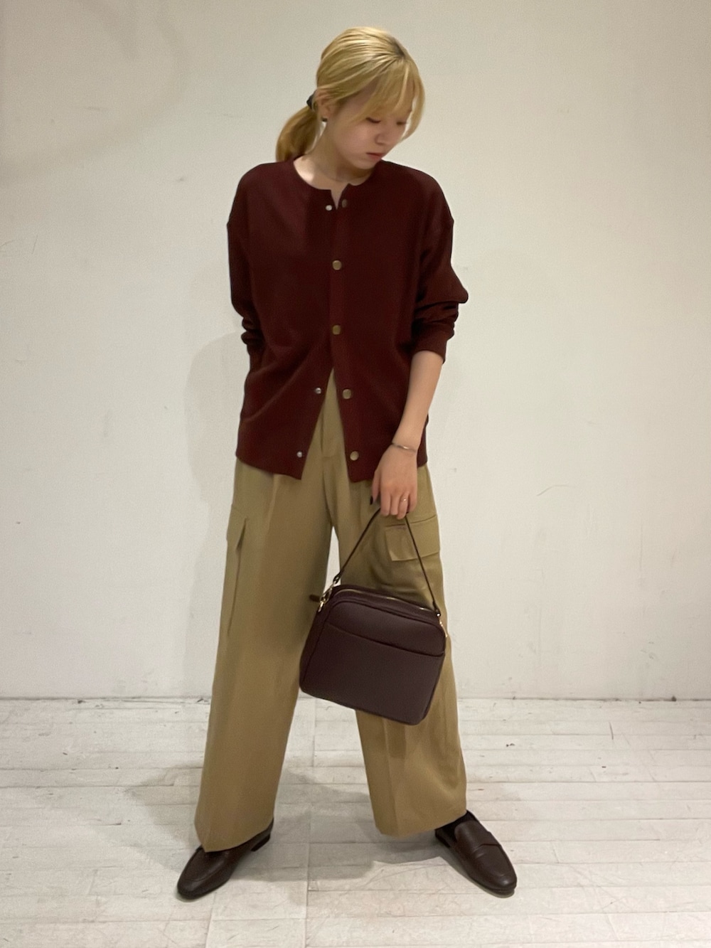 パープル系のその他パンツ、レッド系のカーディガン/ボレロ、レッド系のショルダーバッグを着用したレディースの秋コーディネートの2枚目の写真