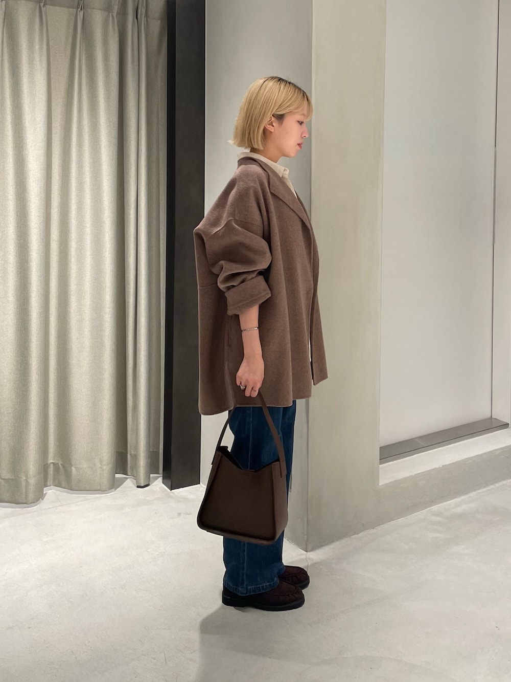 ブラウン系のその他アウター、ベージュ系のシャツ/ブラウス、ブルー系のデニムパンツを着用したレディースの秋コーディネートの3枚目の写真