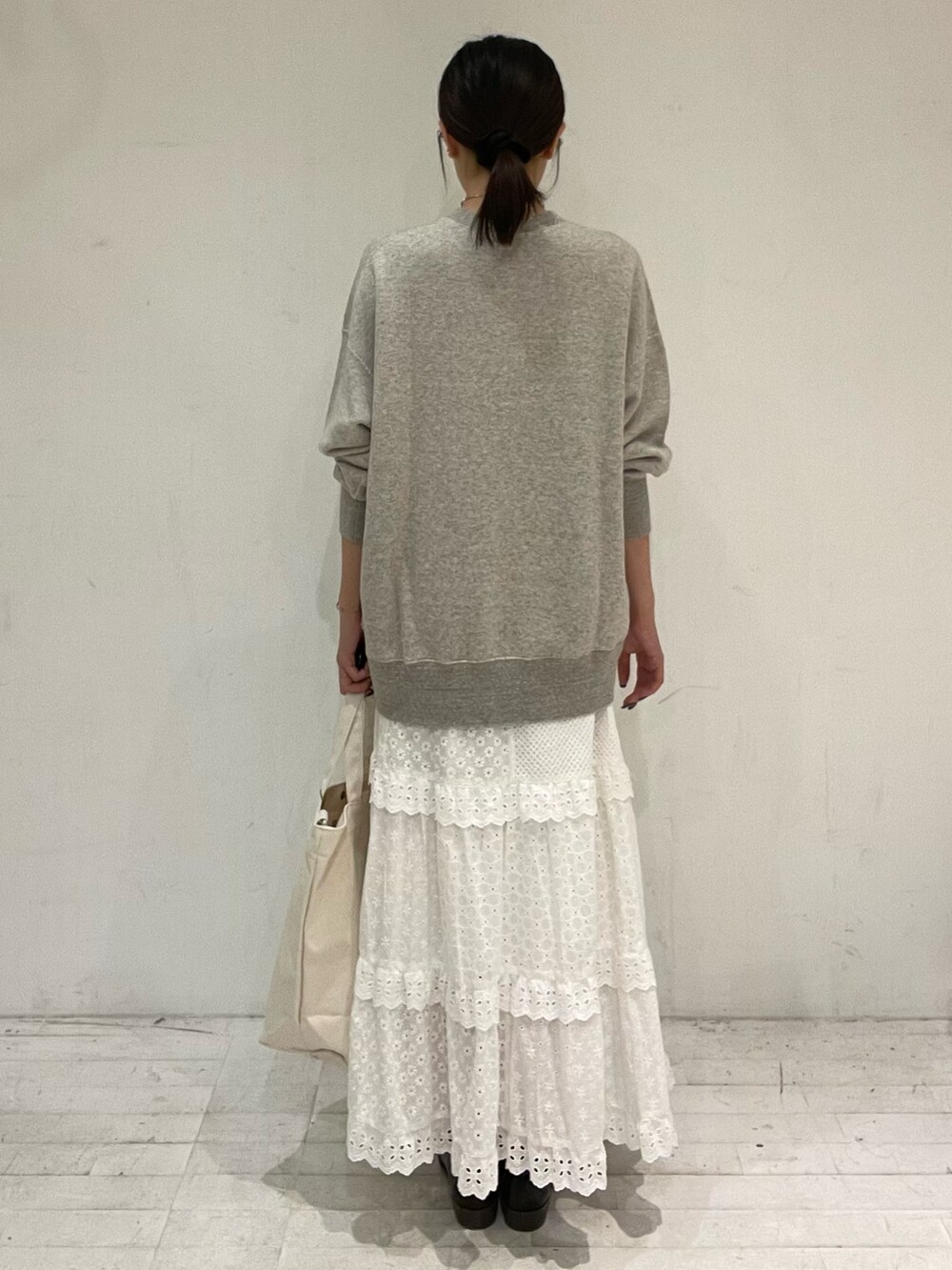 ベージュ系のショルダーバッグ、ホワイト系のスカート、ブラック系のローファーを着用したレディースの秋コーディネートの4枚目の写真