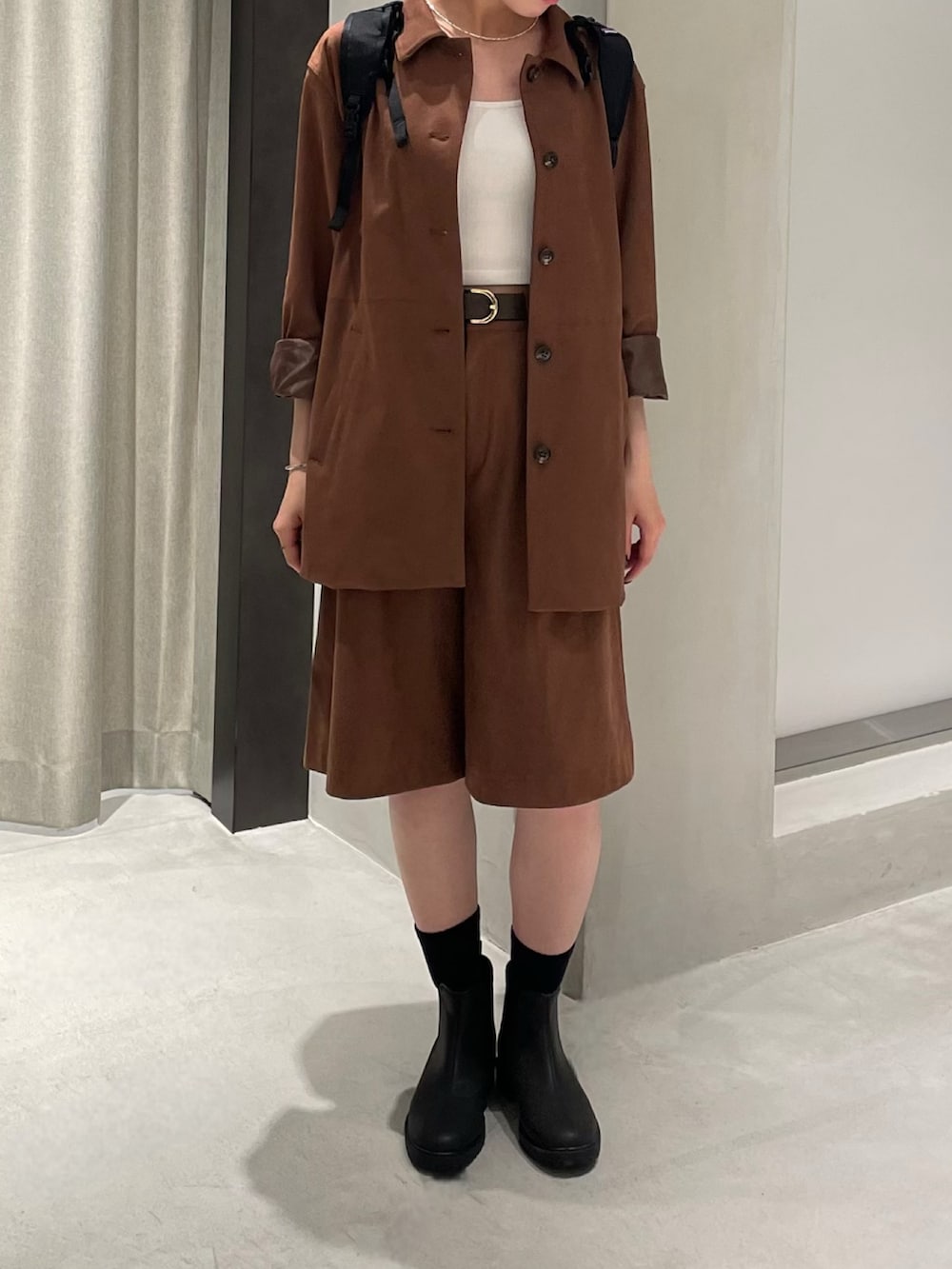ブラック系のレインシューズ、ブラウン系のその他パンツ、ブラウン系のテーラードジャケットを着用したレディースの秋コーディネートの3枚目の写真