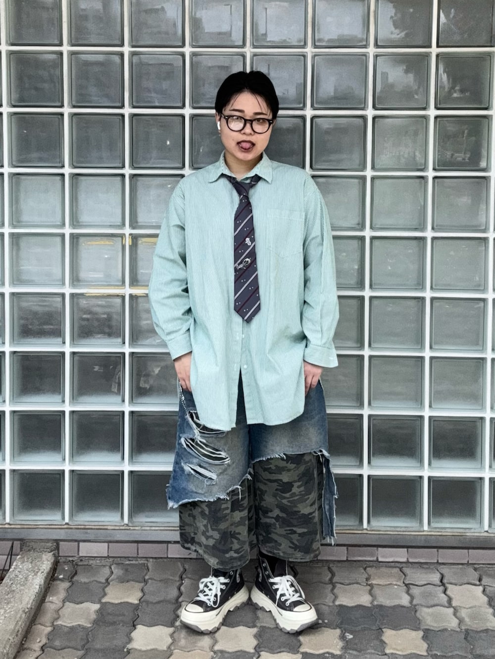 ブルー系のデニムパンツ、グリーン系のシャツ/ブラウス、グレー系のスニーカーを着用したレディースの春コーディネートの2枚目の写真