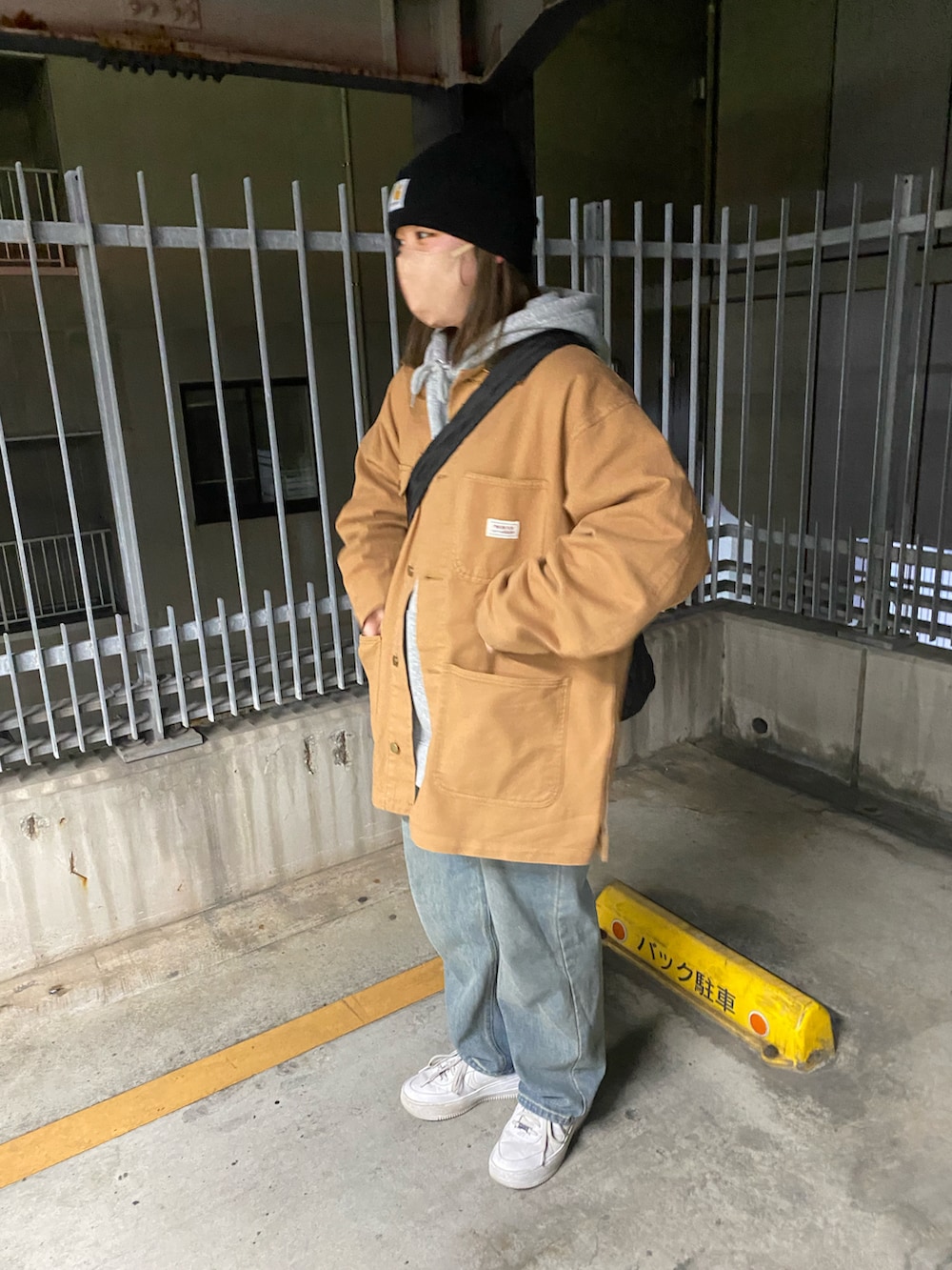 ブラウン系のデニムジャケット、ブルー系のデニムパンツ、ホワイト系のスニーカーを着用したレディースの冬コーディネートの3枚目の写真