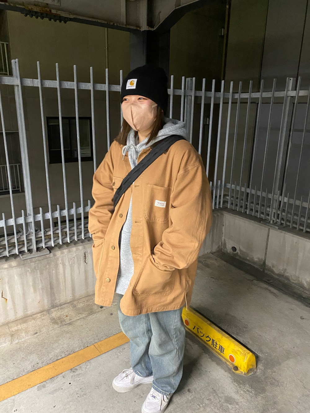 ブラウン系のデニムジャケット、ブルー系のデニムパンツ、ホワイト系のスニーカーを着用したレディースの冬コーディネートの2枚目の写真