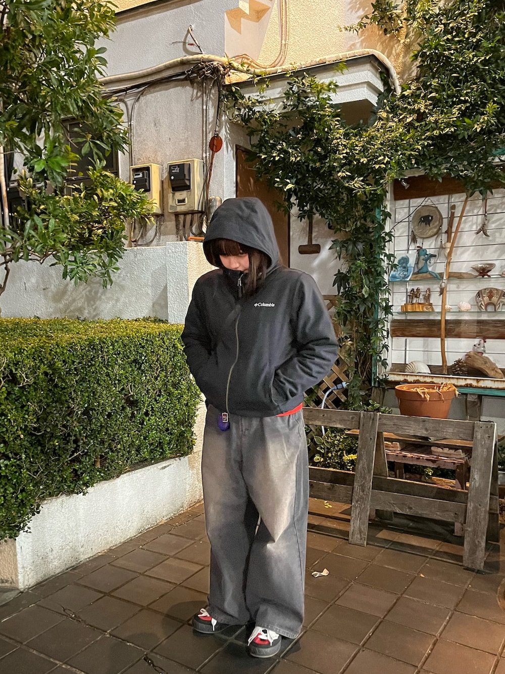 ブラック系のマウンテンパーカー、ブラック系のデニムパンツ、レッド系のスニーカーを着用したレディースの冬コーディネートの2枚目の写真