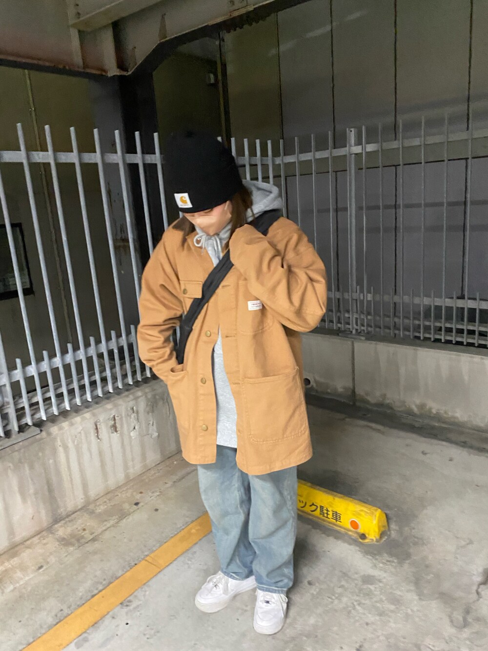 ブラウン系のデニムジャケット、ブルー系のデニムパンツ、ホワイト系のスニーカーを着用したレディースの冬コーディネートの4枚目の写真
