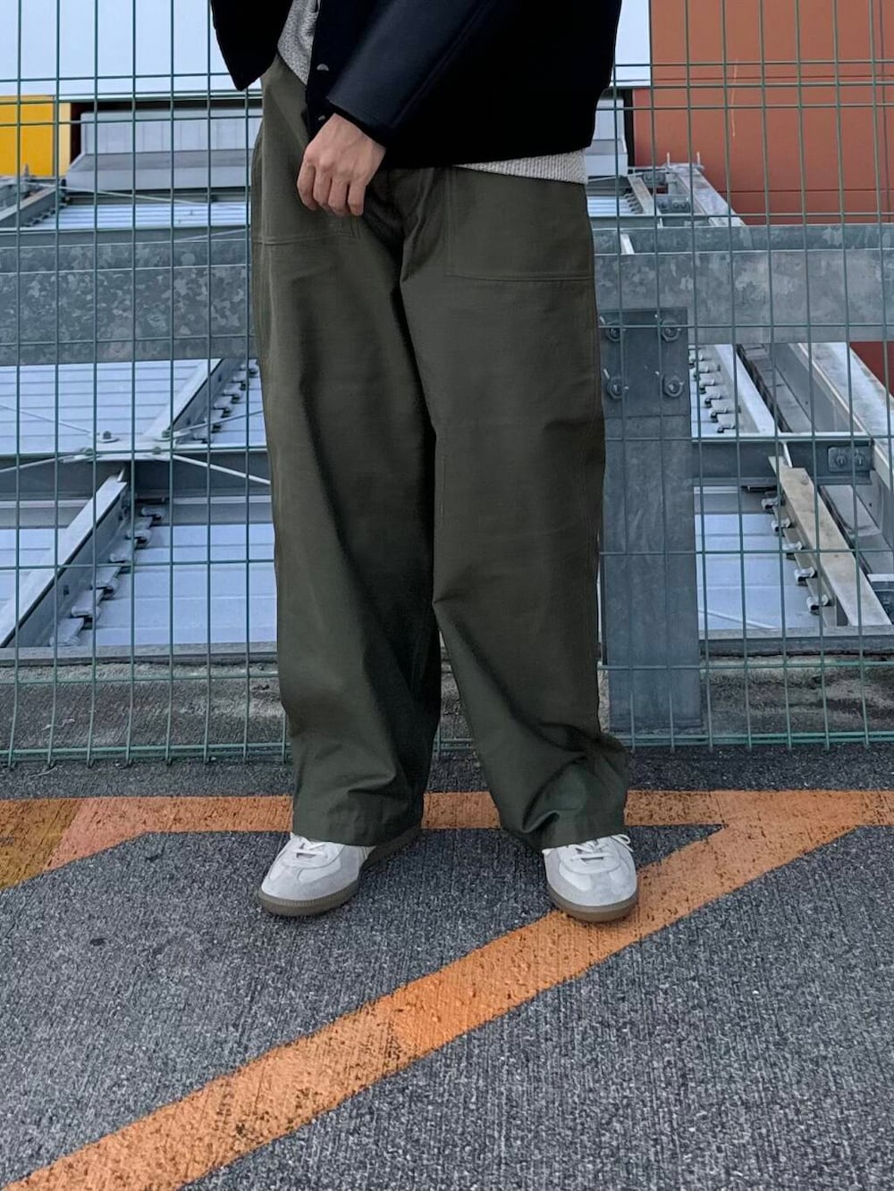 ベージュ系のTシャツ/カットソー、ホワイト系のスニーカー、ブラック系のスタジャンを着用したメンズの秋コーディネートの4枚目の写真