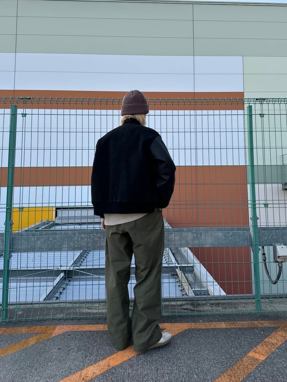 ベージュ系のTシャツ/カットソー、ホワイト系のスニーカー、ブラック系のスタジャンを着用したメンズの秋コーディネートの2枚目の写真