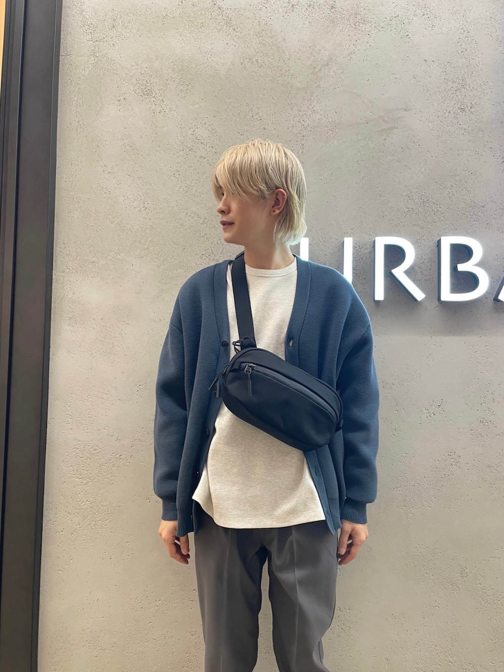 グレー系のカーディガン/ボレロ、ブラック系のショルダーバッグ、グレー系のその他パンツを着用したメンズの春コーディネートの2枚目の写真