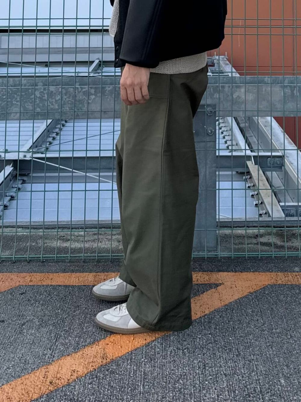 ベージュ系のTシャツ/カットソー、ホワイト系のスニーカー、ブラック系のスタジャンを着用したメンズの秋コーディネートの5枚目の写真