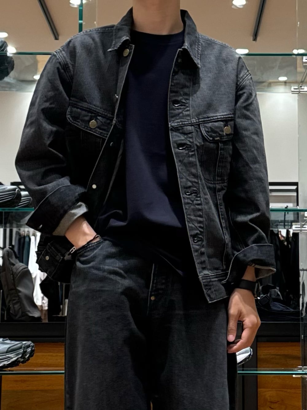 ブラック系のデニムパンツ、ブラック系のドレスシューズ、ブラック系のデニムジャケットを着用したメンズの秋コーディネートの2枚目の写真