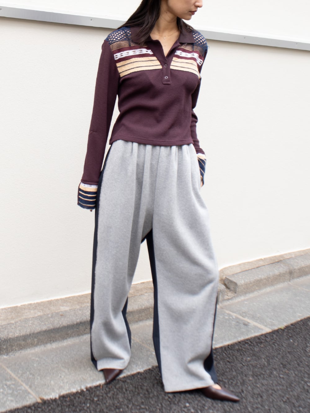 レッド系のポロシャツを着用したレディースの春コーディネートの2枚目の写真