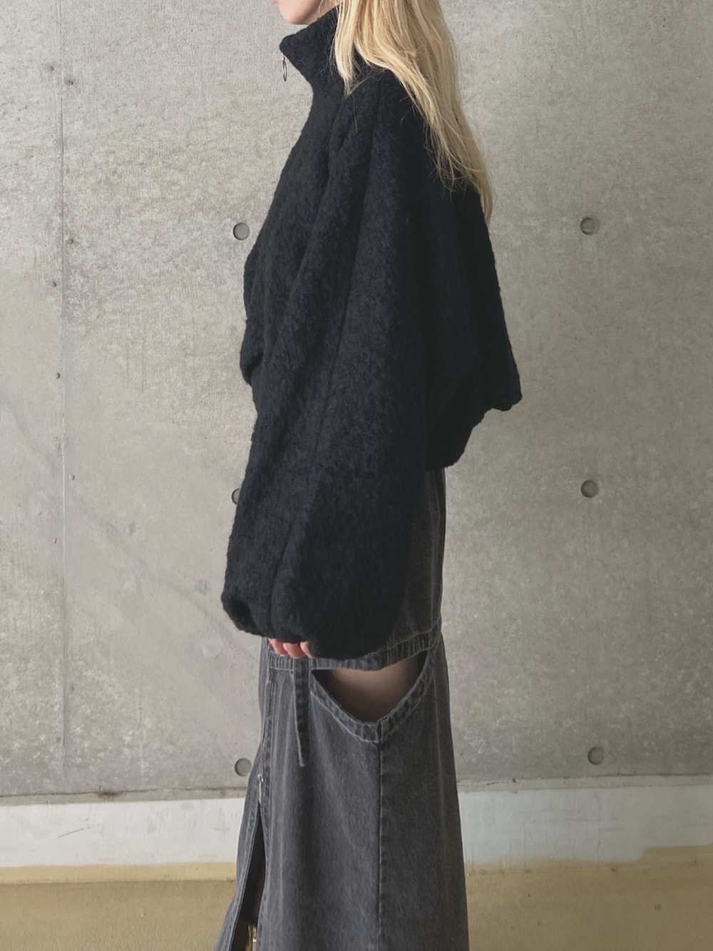 ブラック系のブルゾン、ブラック系のデニムスカートを着用したレディースの冬コーディネートの2枚目の写真